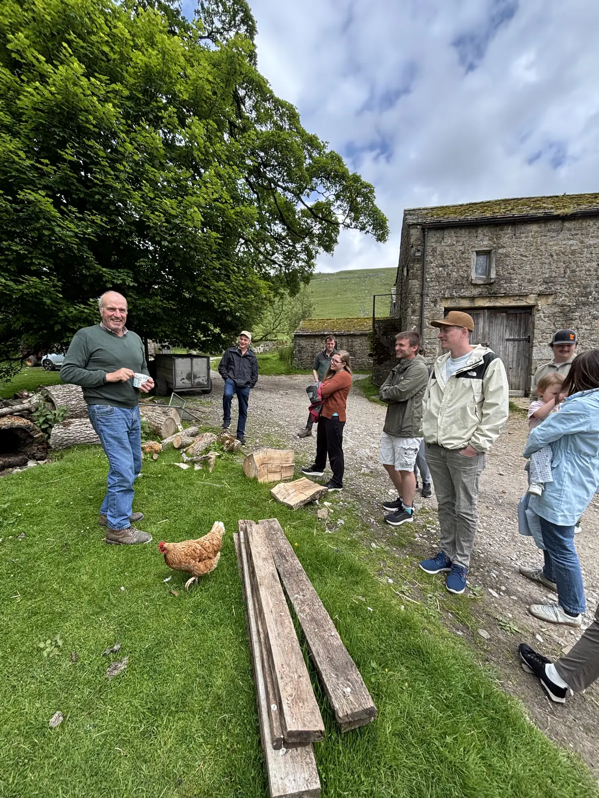 Guests meeting farm animals on a Yorkshire Dales farm visit during a private day tour